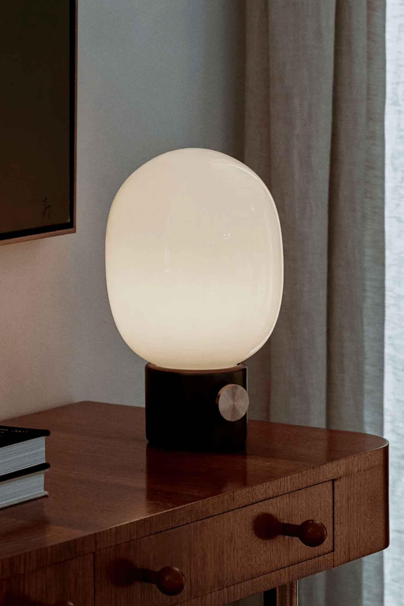 Black Marble JWDA Table Lamp by Menu, shown lit on a table