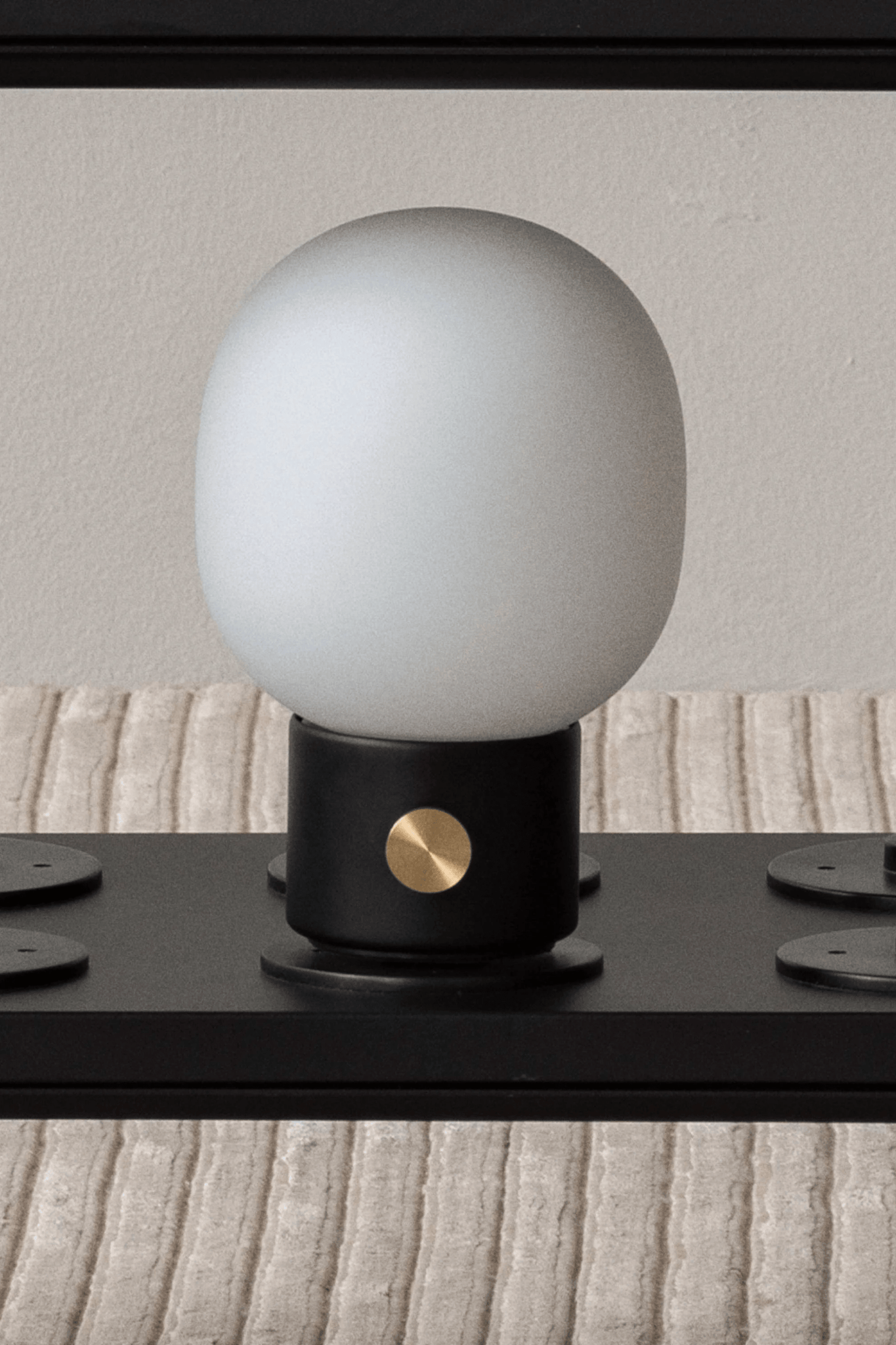 Black Portable JWDA Table Lamp by Menu, shown on stand