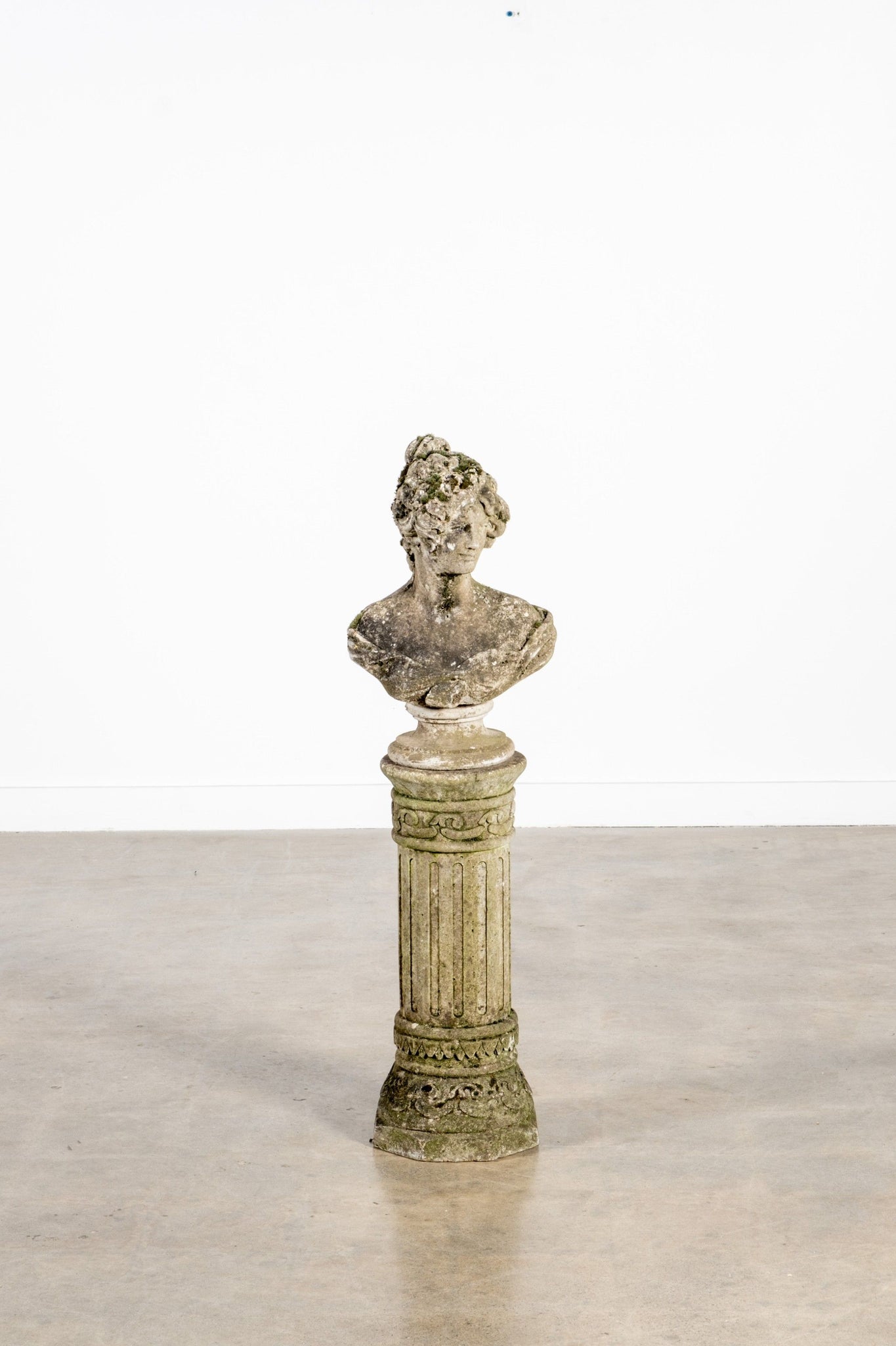 Decorative bust on a pedestal against a white background