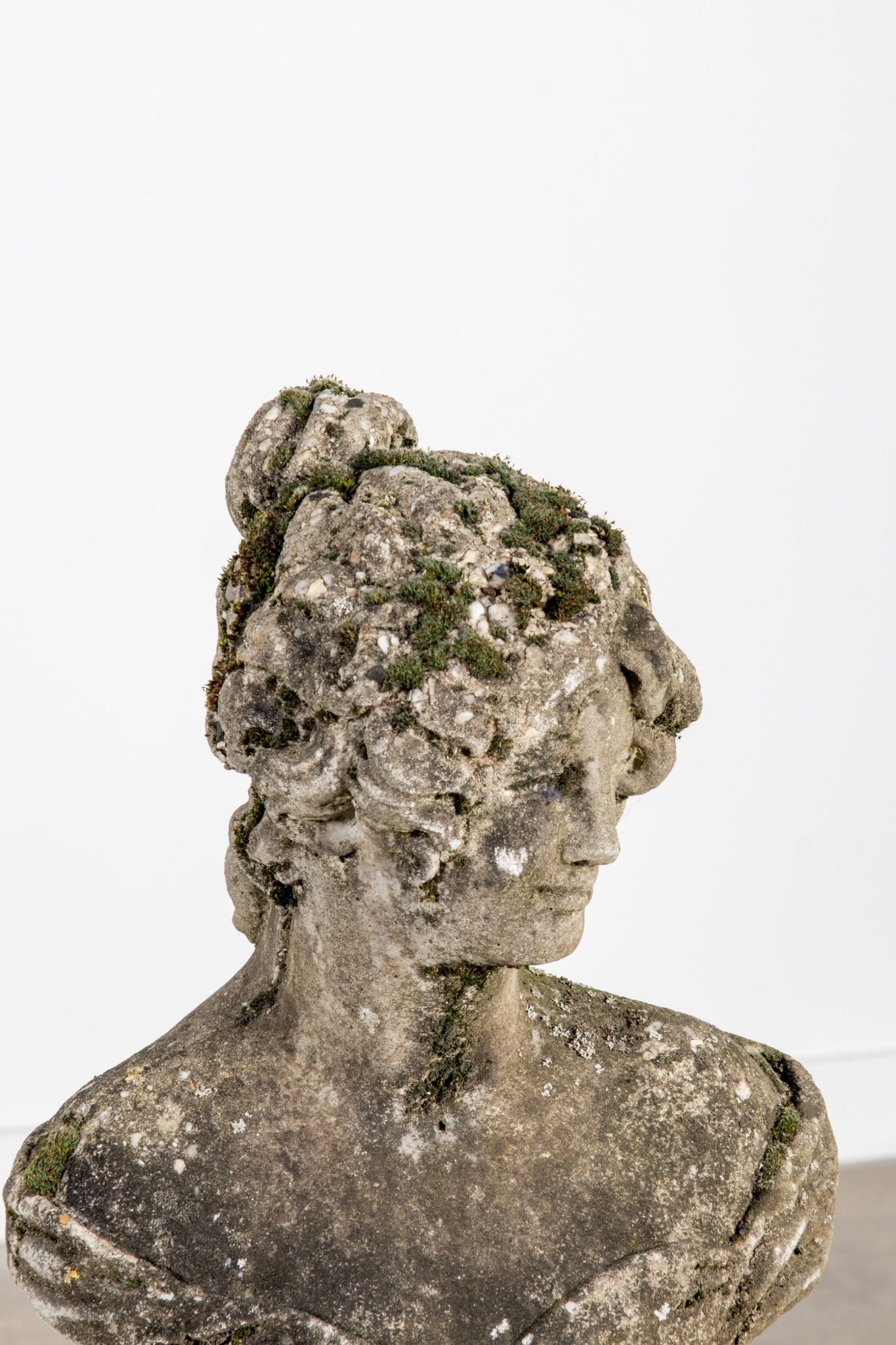 Stone bust with intricate detailing on a white background