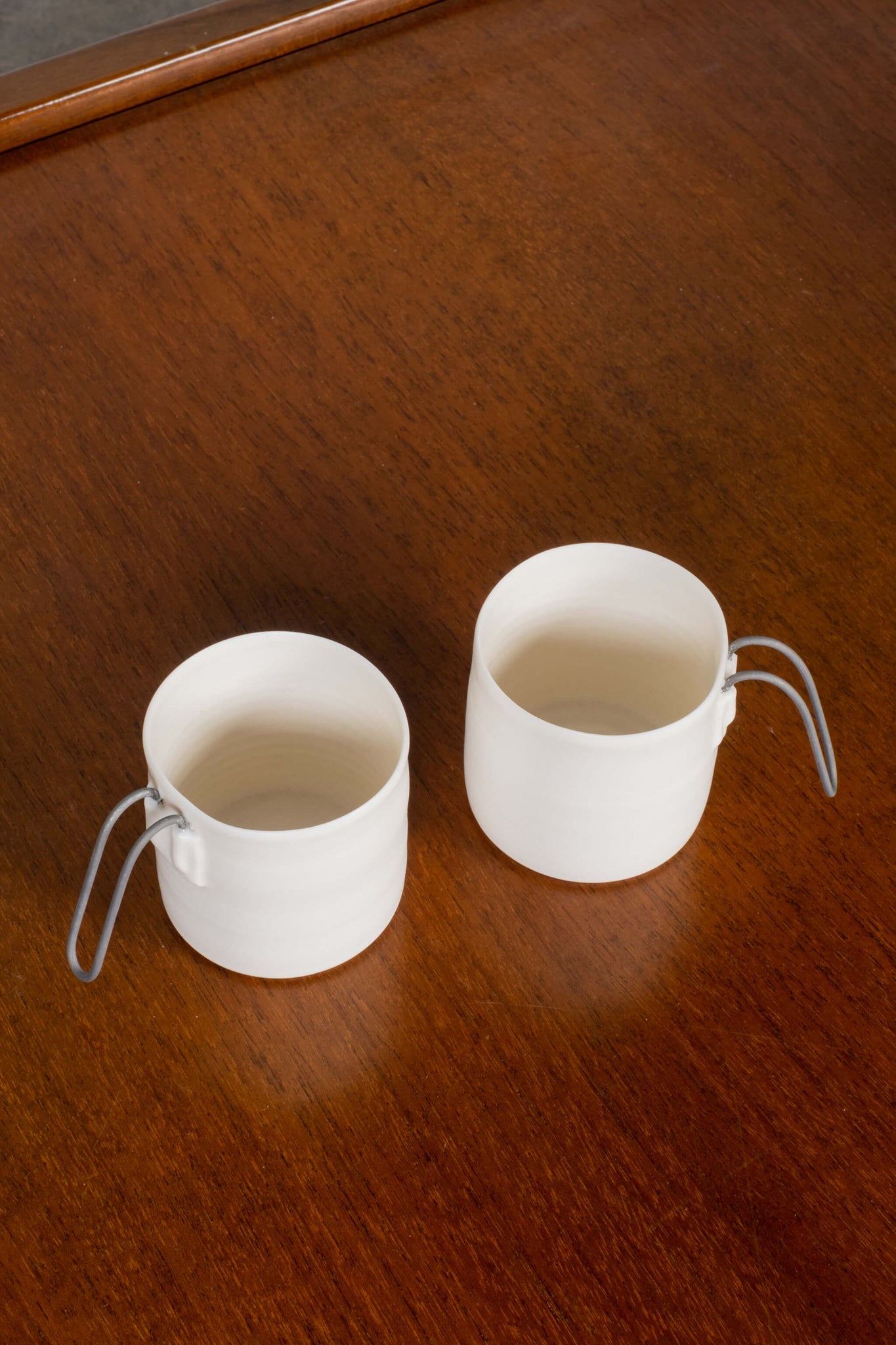 Porcelain Espresso cup with straight metal handle, top view, shown side by side