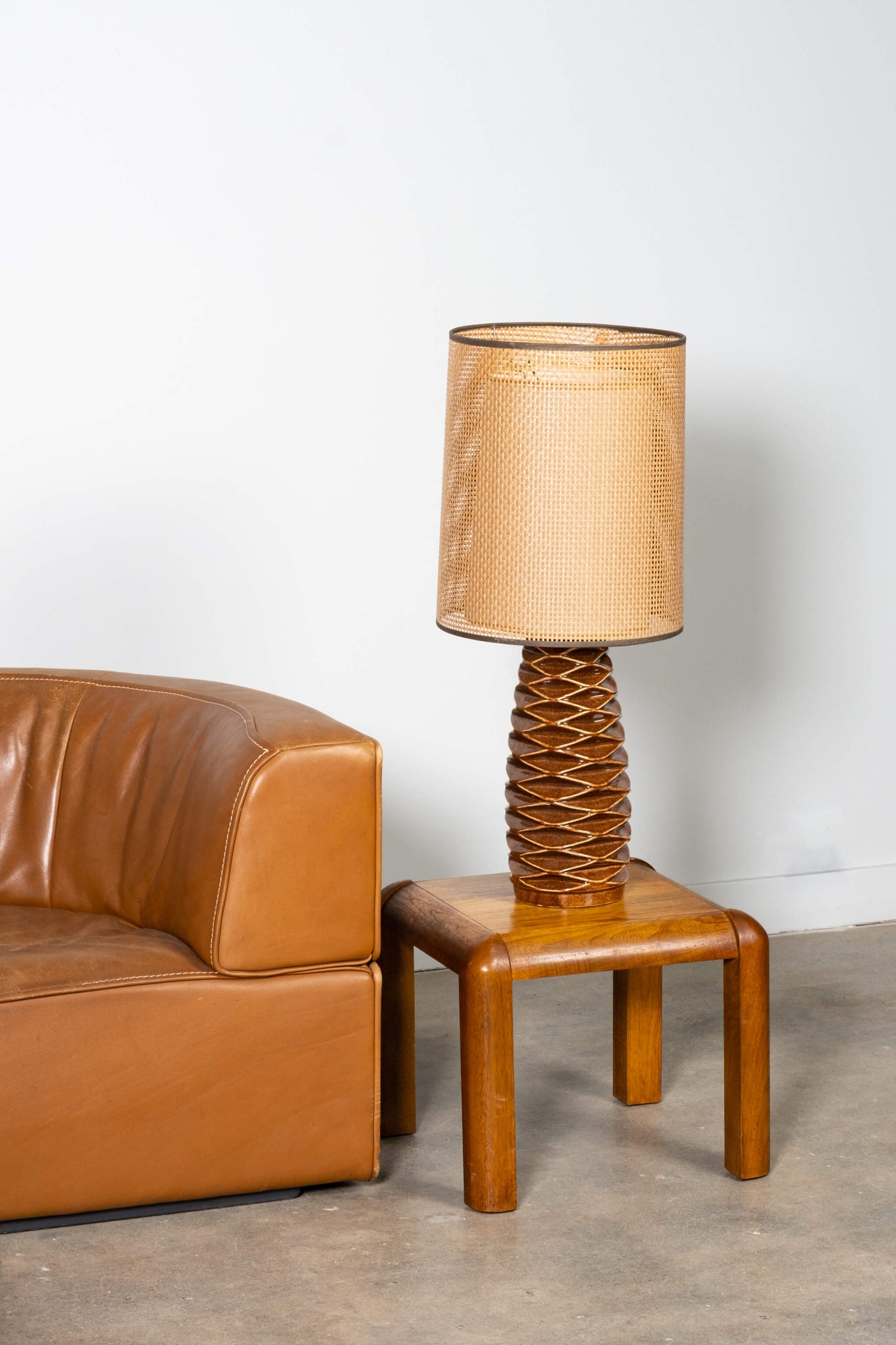 Vintage Ceramic Table Lamp with Double Layer Shade, shown on a wood end table with a brown leather couch