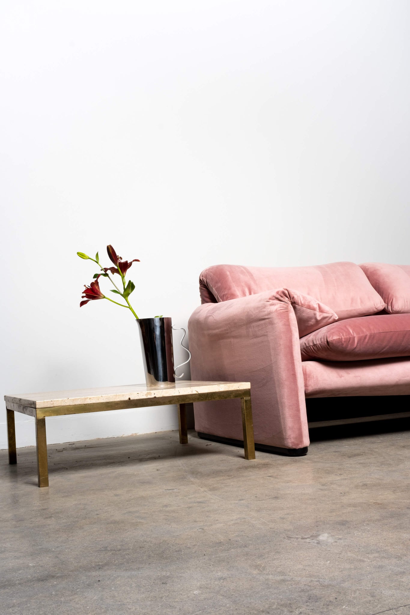 Vintage Low Profile Natural Travertine Coffee Table with Brass Base, shown with pink fabric sofa and vase with flowers