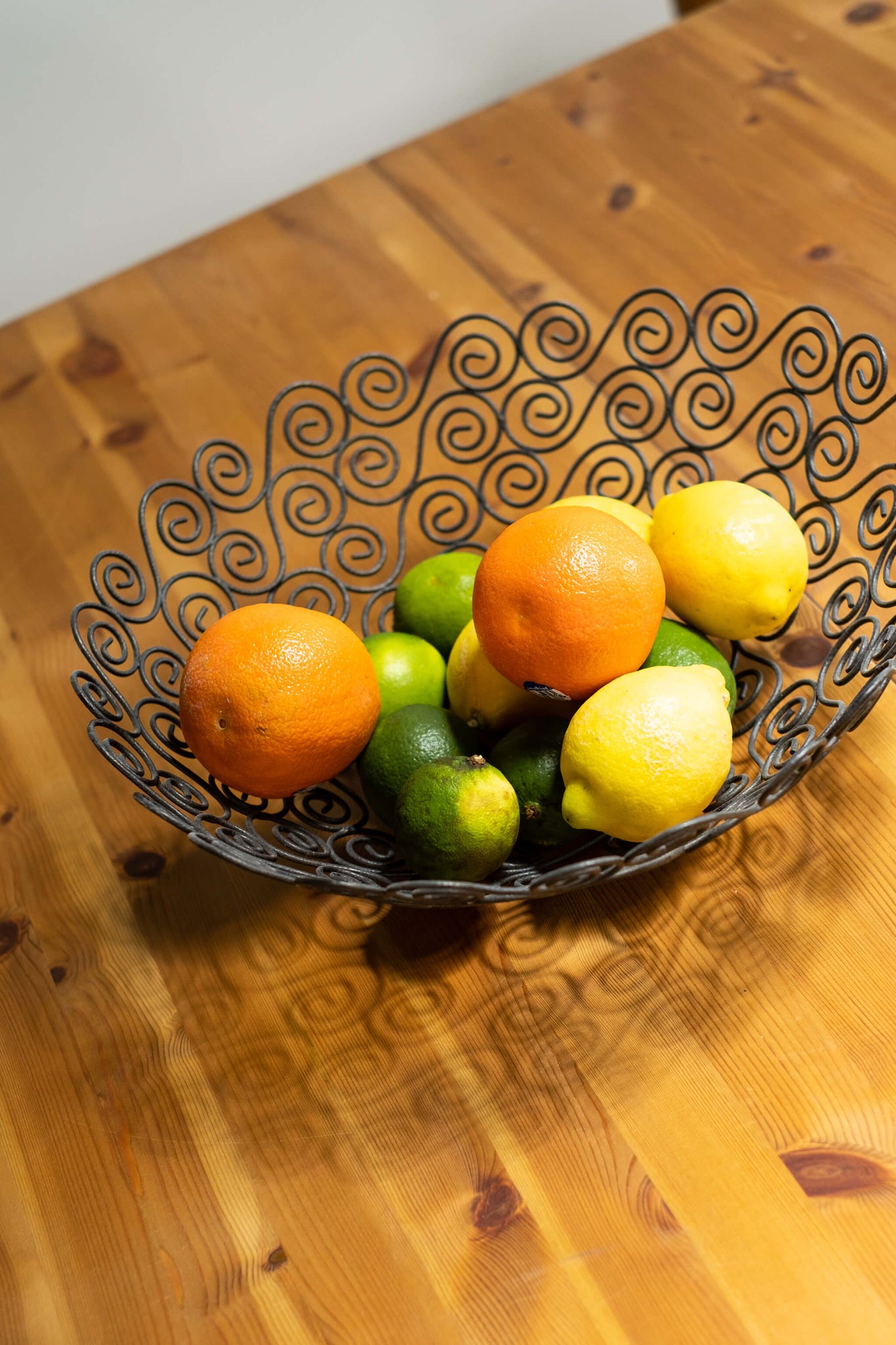 Vintage Ornate Black Metal Wire Basket, shown with citrus fruit