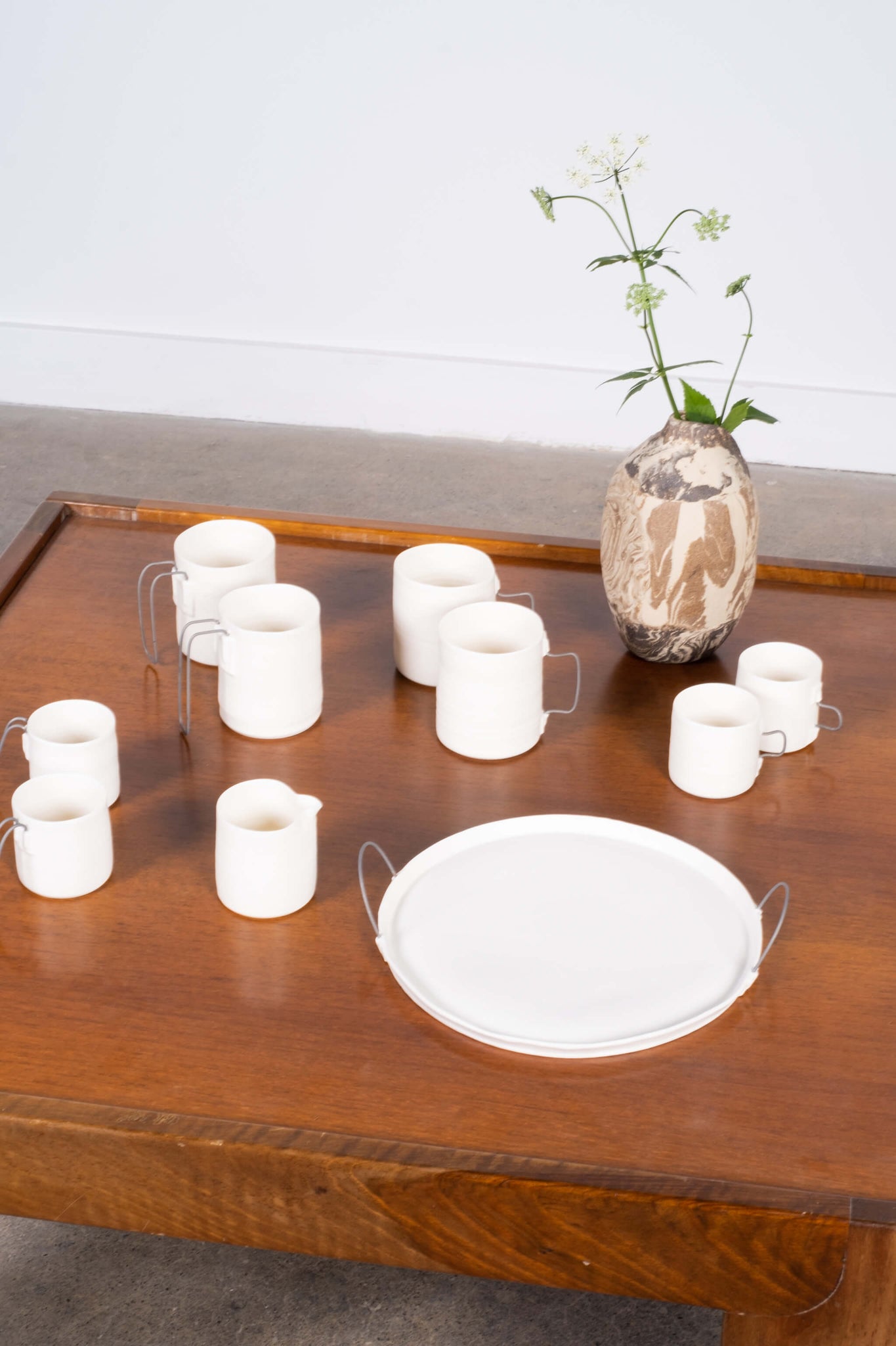 Porcelain Mug with Straight Metal Handle Nathalie Audiber, shown on wooden table